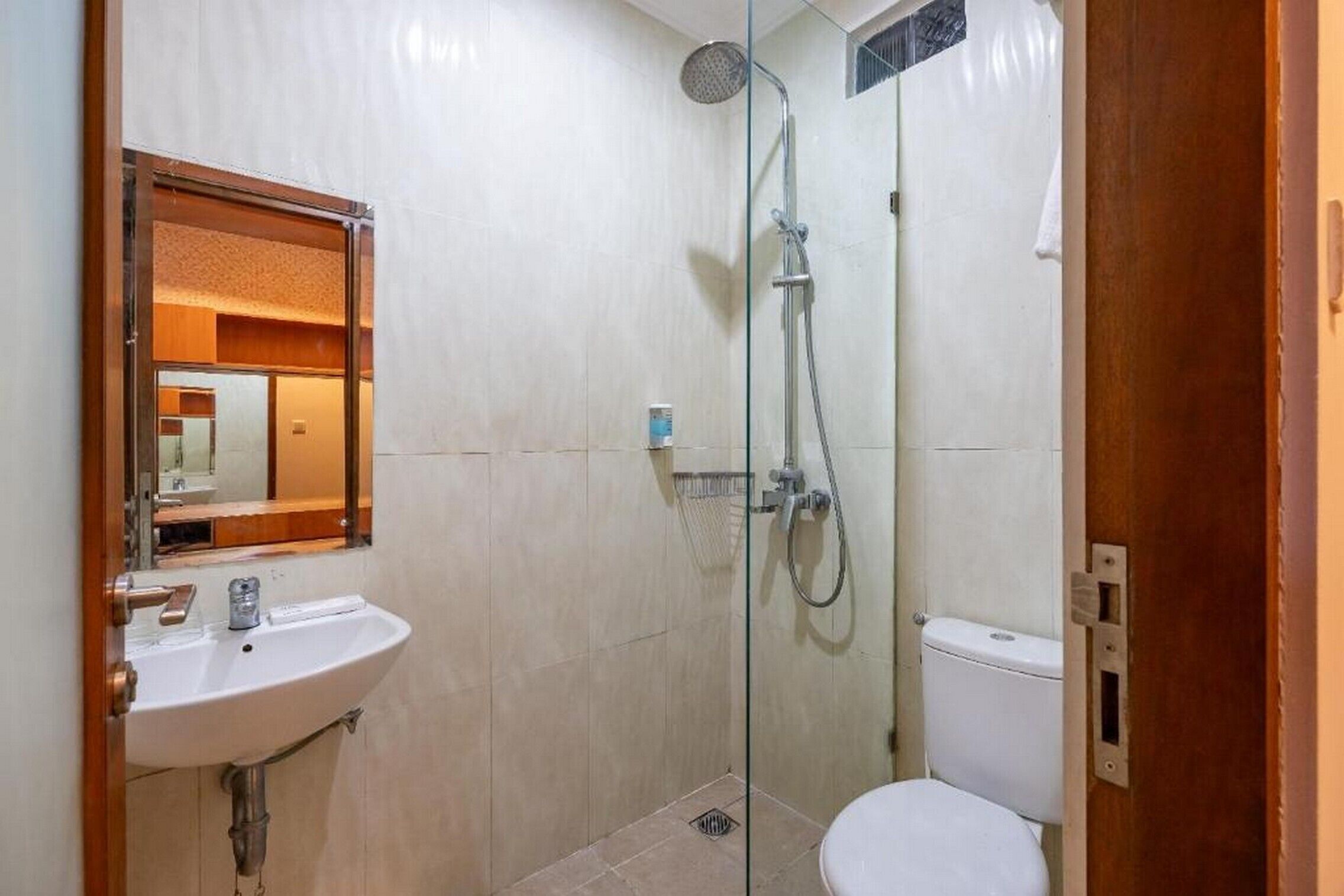 A bathroom with a glass-enclosed shower, a white sink, and a toilet.