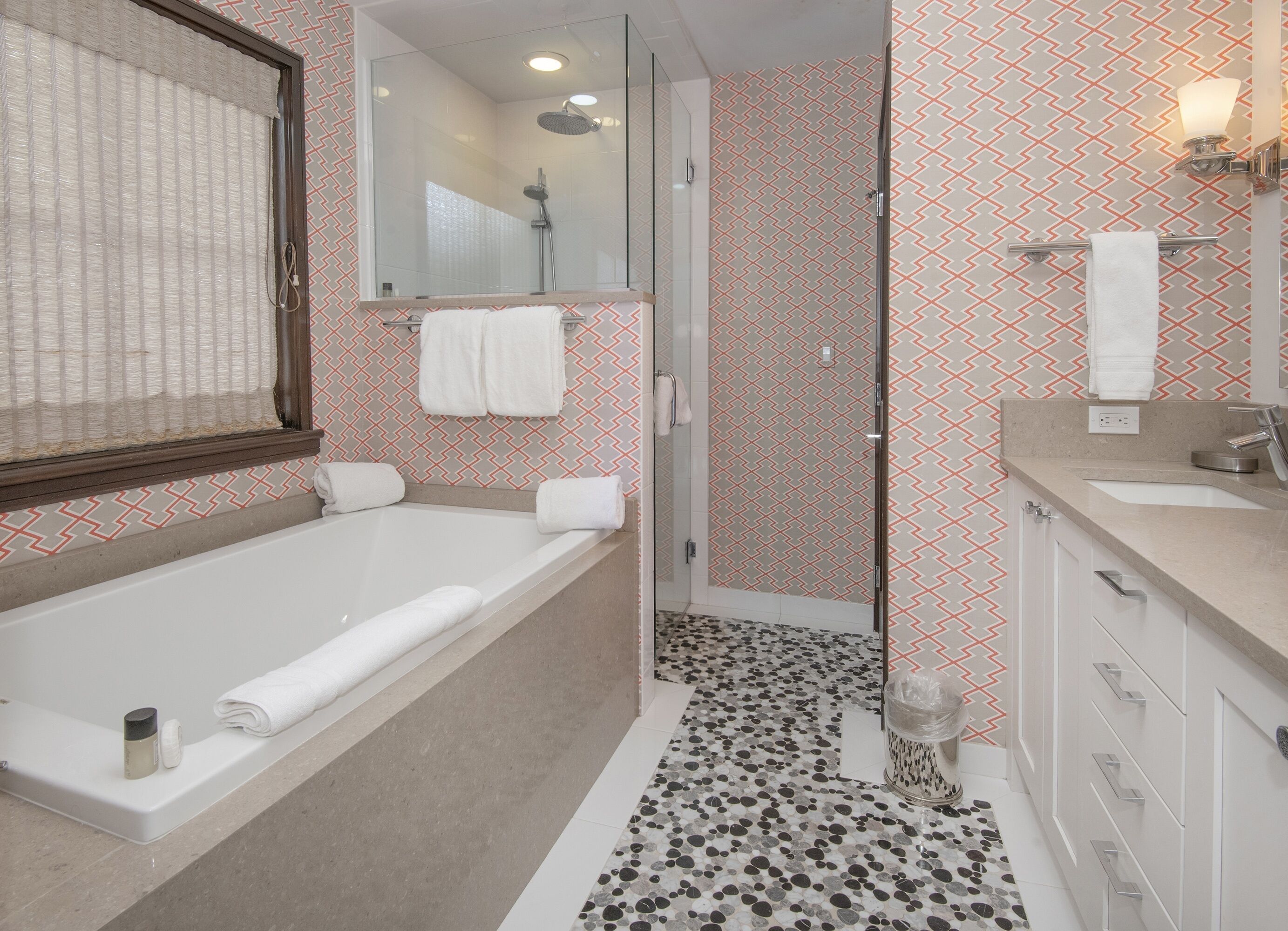 A modern bathroom with a bathtub, shower, and vanity.