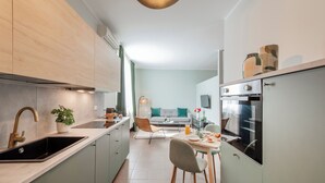 A modern kitchen with a sink, stove, and dining area. - Bazzi 49 - Università Bocconi (Milan)