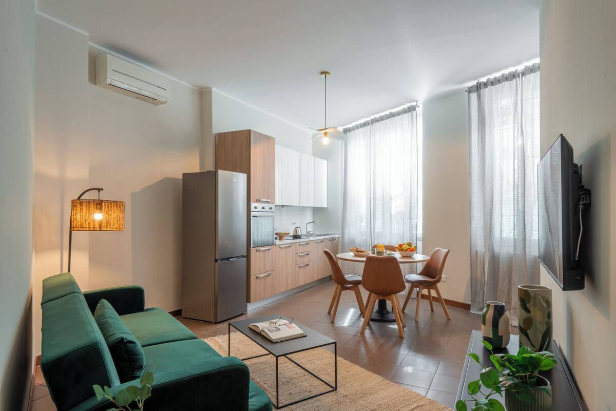 Une cuisine moderne équipée d’un réfrigérateur, d’une cuisinière et d’un coin repas avec des chaises et une table.