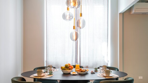 A dining area with a round table, chairs, and a fruit bowl. - Bazzi 49 - Università Bocconi (Milan)