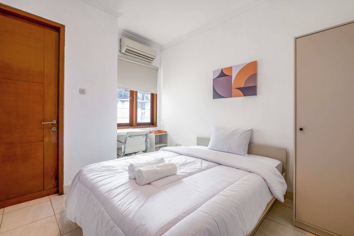 Une chambre d’hôtel comprenant un lit, un bureau, une chaise et une armoire.