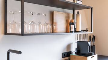 A modern kitchen with a black sink, stainless steel appliances, and a wooden countertop.