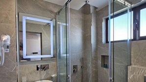 A modern bathroom with a glass-enclosed shower, a round sink, and a large mirror. - Adele Hotel Ksamil (Ksamil)