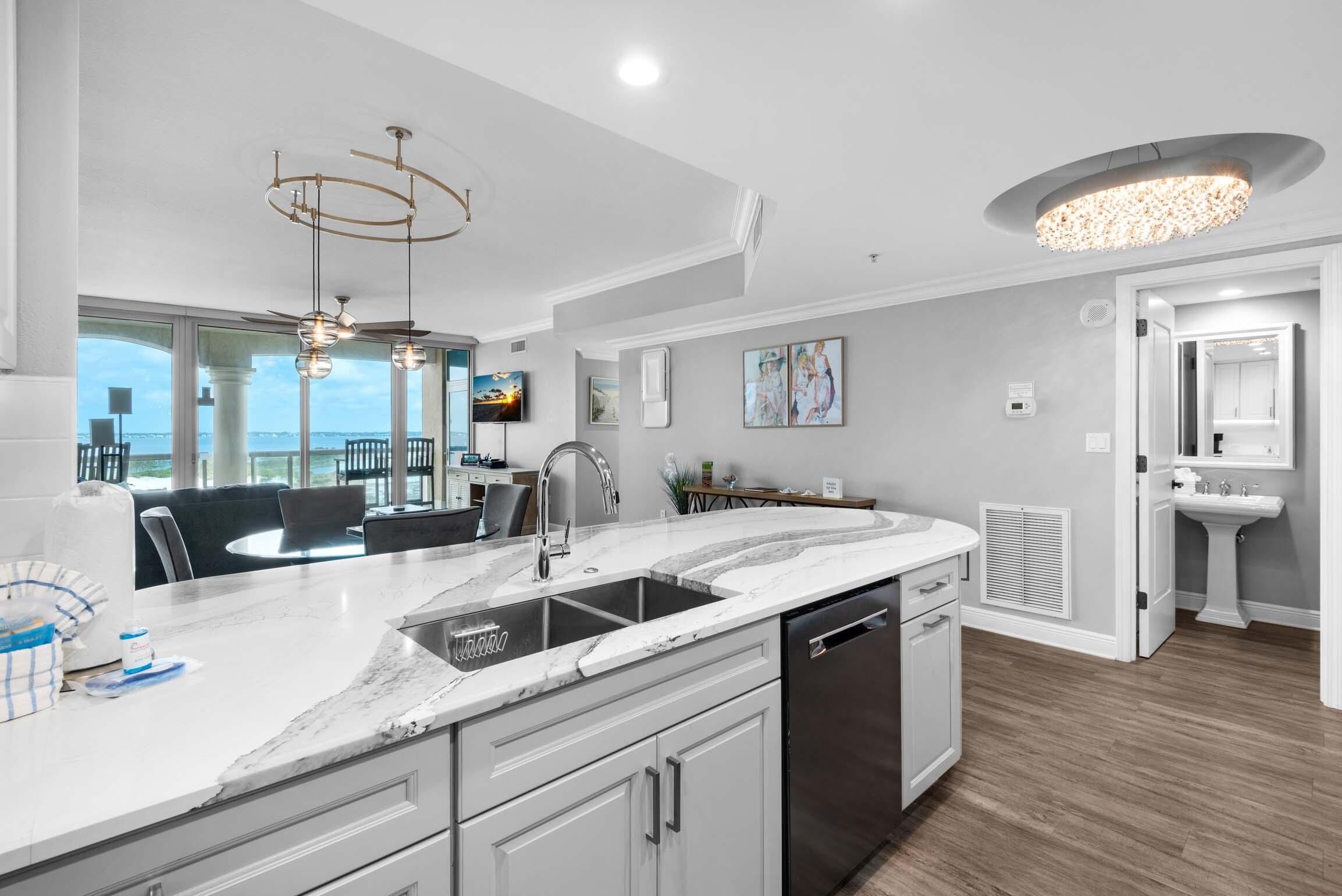 A modern kitchen with a large island, stainless steel appliances, and a view to the outdoors.