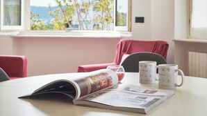 Eine Zeitschrift auf einem Tisch, zusammen mit zwei Tassen und einem Glas roter Flüssigkeit.