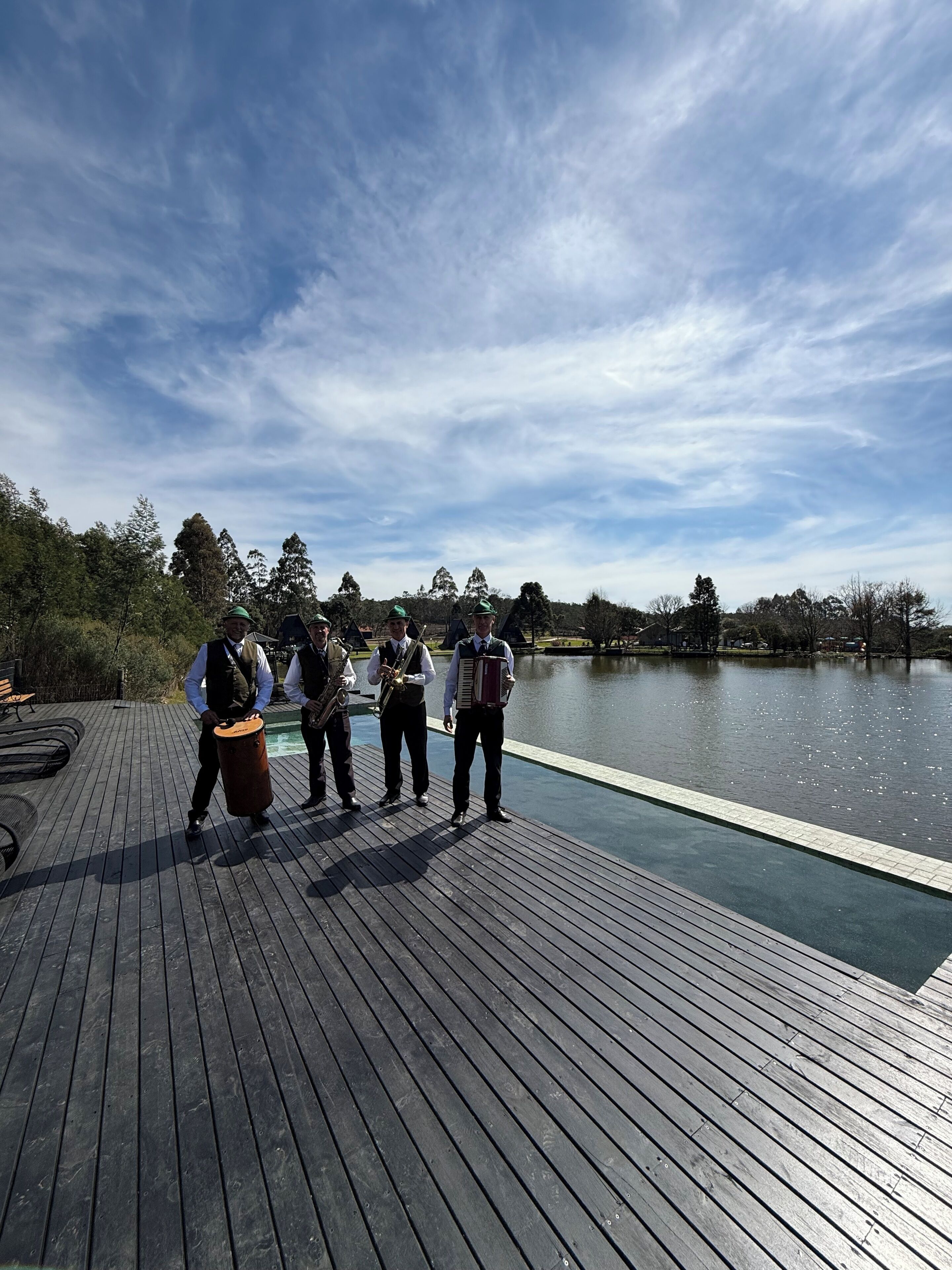 A wooden deck with a view of a lake and trees.