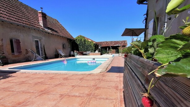 A swimming pool with a tiled deck, a wooden fence, and a building with a tiled roof. - FARMHOUSE GITE WITH SHARED POOL - A CHANGE OF SCENERY FOR FAMILY AND FRIENDS (Cachen)