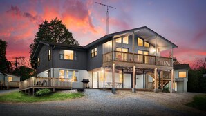 Une maison à deux étages avec un balcon, une véranda et un garage.