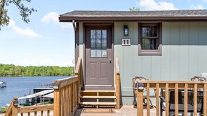 Une jetée en bois mène à une maison avec une porte marron et le numéro 11 sur le mur.