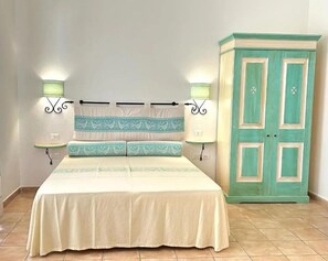 A bedroom with a bed, two bedside lamps, a nightstand, and a wardrobe. - Acqua di Mare Hotel e Resort (Sorso)
