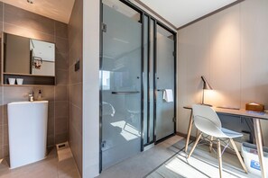 A modern bathroom with a glass shower enclosure, a white sink, and a mirror. - Hanting Hotel Shanghai Hongqiao Zhongshan West Roa (Shanghai)
