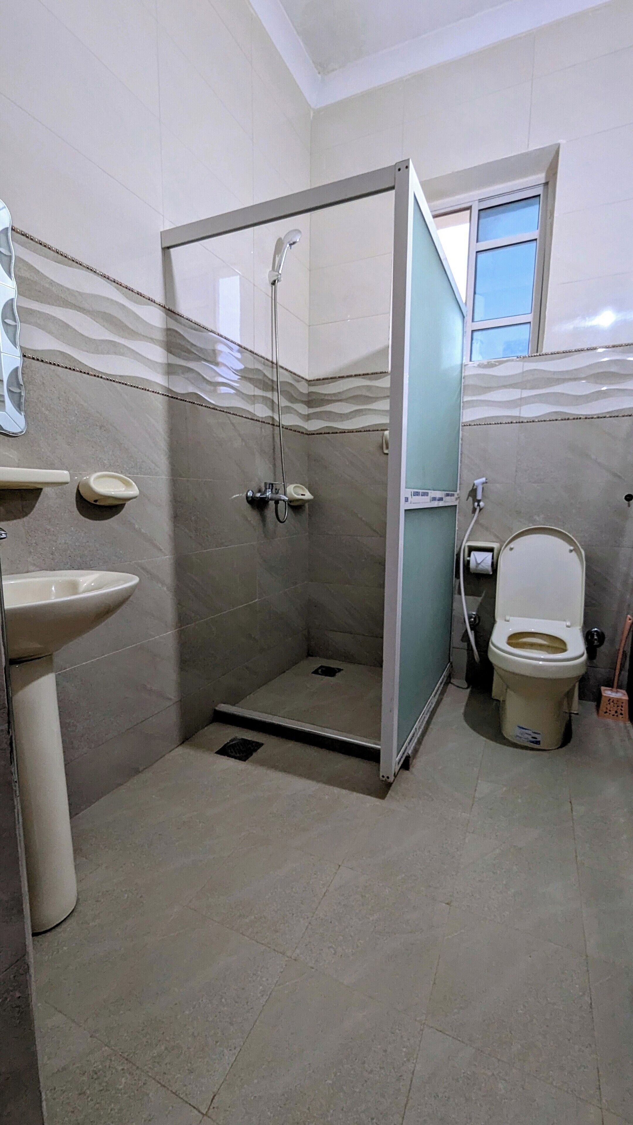 A bathroom with a shower, toilet, and sink.