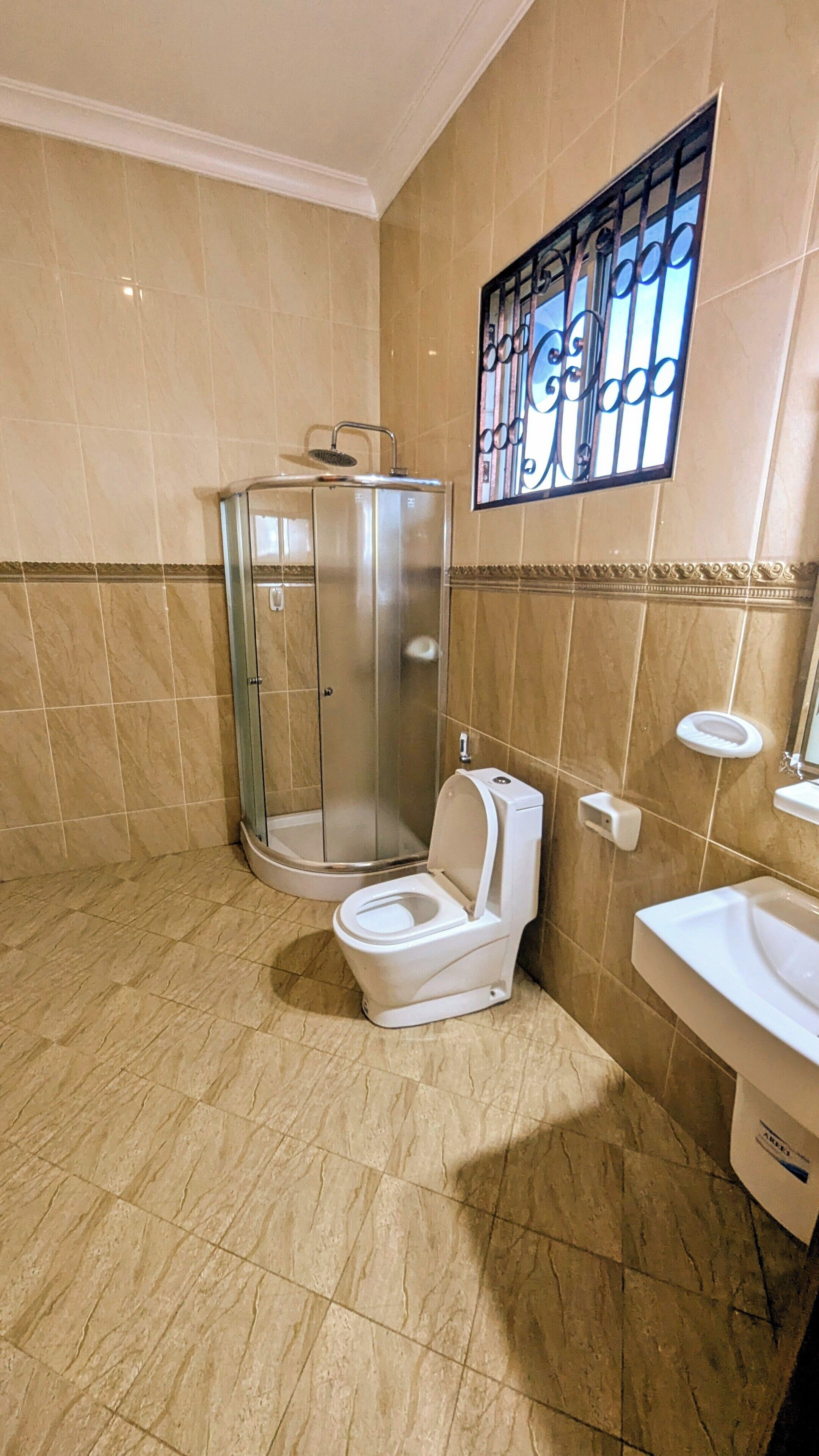 A bathroom with a glass-enclosed shower, a toilet, and a sink.