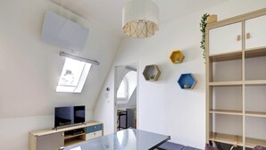A modern room with a loft bed, a desk, a TV, and a large window. - Champs-Élysées - 1BR (Paris)
