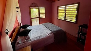 A bedroom with a bed, a window, and a door. - Castaway Blue Hole Long Caye, Belize (Long Caye Lighthouse Atoll  Belize City)