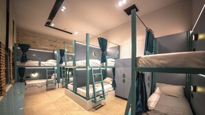 A bunk bed room with a stone wall, a wardrobe, and a mirror. - Vega 43 Hostel (Sarande)