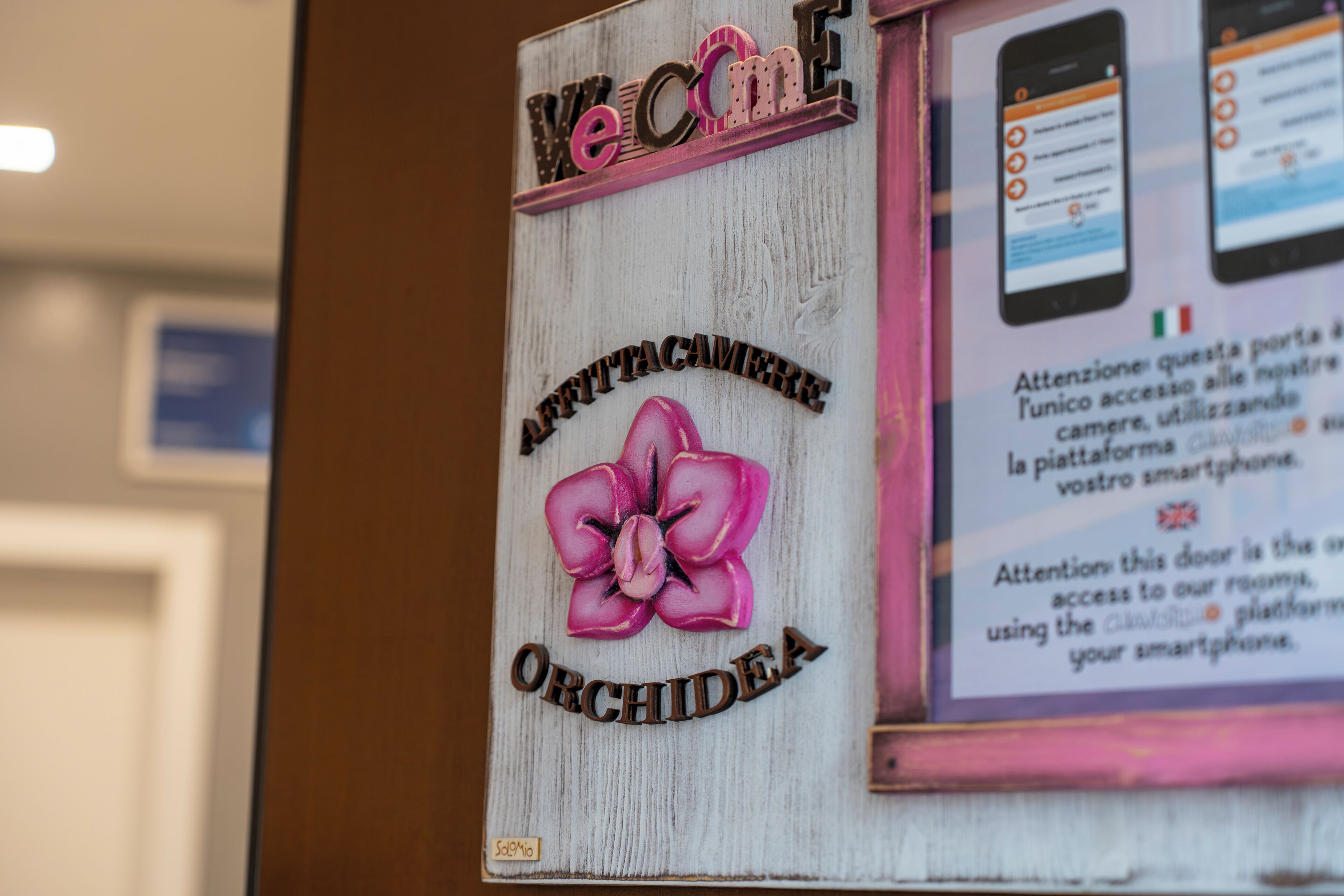 A wooden sign with 'Welcome' and 'Orchidée' text, and a flower illustration.