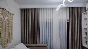 A bedroom with a bed, a sofa, and a macrame wall hanging. - A charming & ideal sea view studio apartment in  ,Hurgahda with a private beach (Red Sea Governorate)