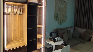 A modern living room with a wooden wardrobe, a round coffee table, a sofa, and a hanging macrame decoration. - A charming & ideal sea view studio apartment in  ,Hurgahda with a private beach (Red Sea Governorate)