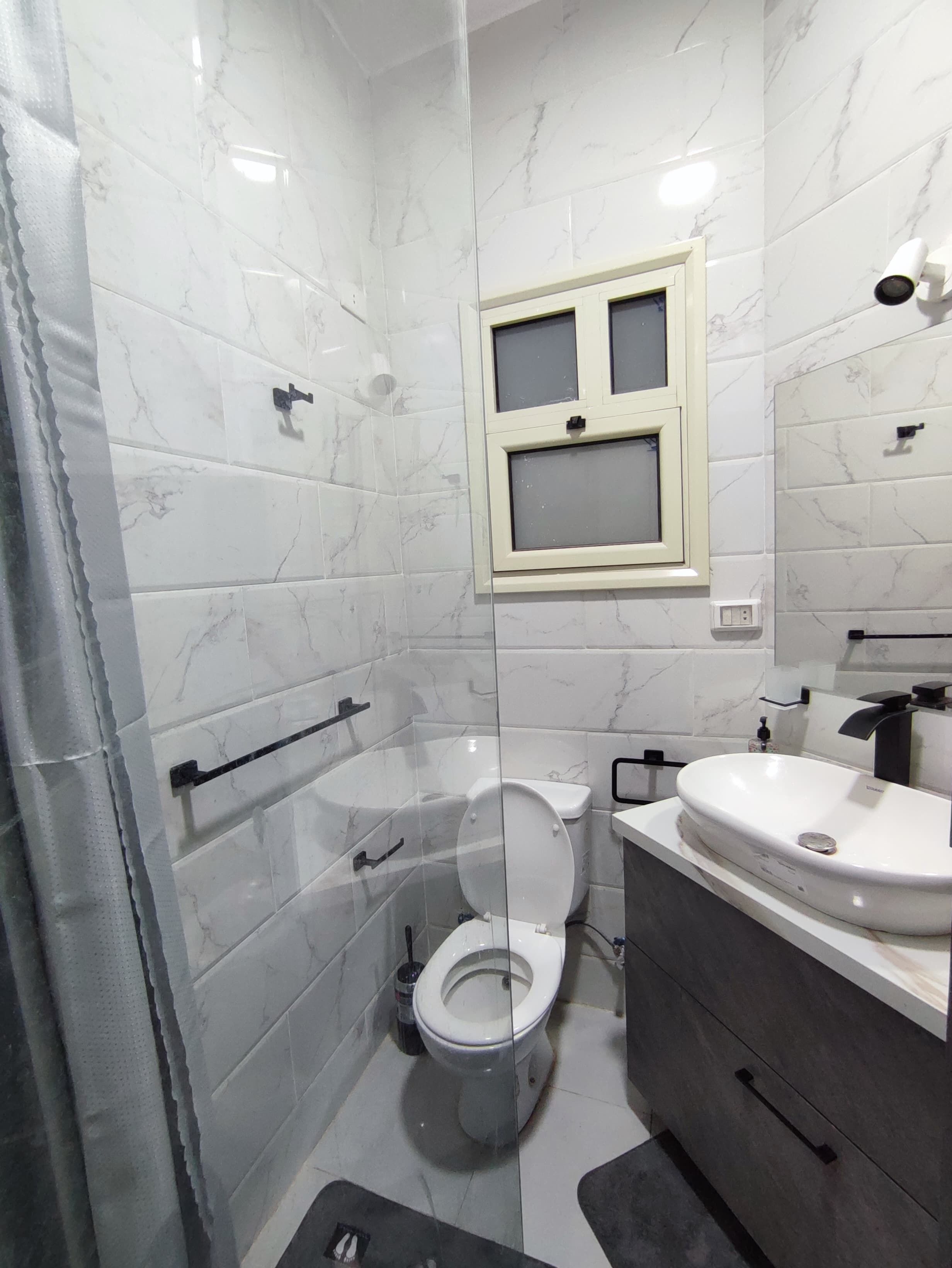 Une salle de bain moderne équipée de toilettes, d’un bidet et d’un lavabo.
