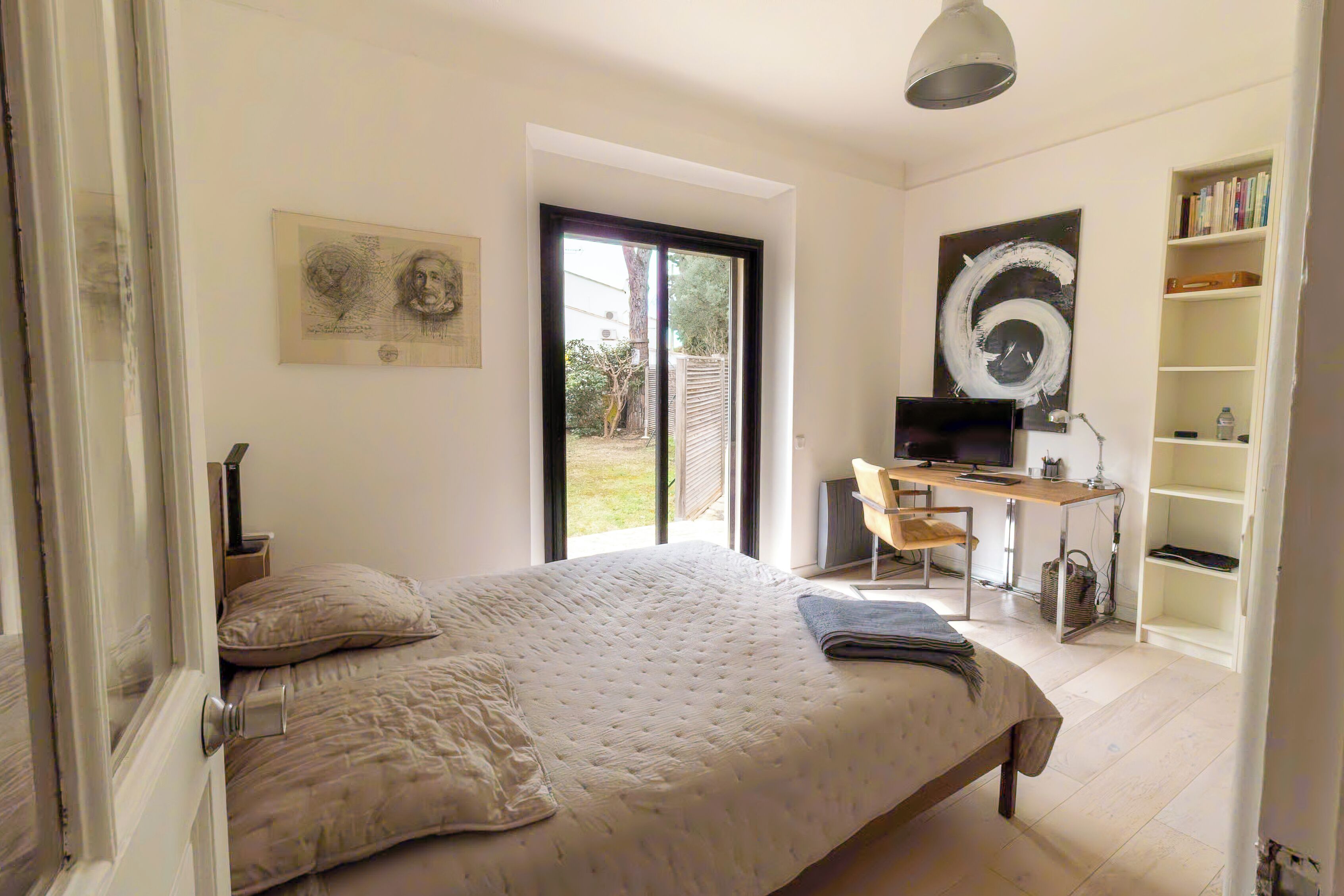 A bedroom with a bed, a desk, a chair, and a bookshelf.