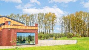 A modern house with a brick exterior and large glass windows. - Beautiful Barn Conversion - Orchard Escape for 12 (Cropthorne)