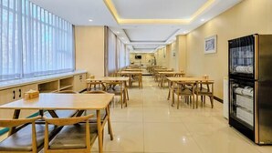 A spacious dining area with long tables and chairs, a refrigerator, and a window with blinds. - Jinyuan Juntai Business Express Hotel (Shijiazhuang)