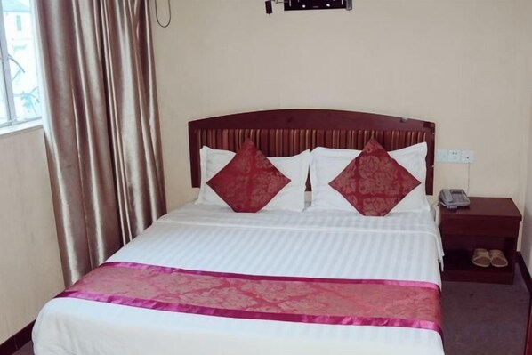 A hotel room with a bed, a nightstand, and a pair of shoes on the floor. - Gao Feng Hotel (Shanghai)