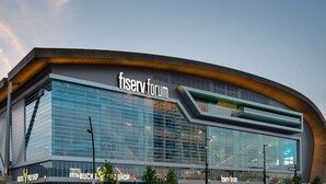 A modern building with a curved facade and large glass windows, labeled "fiserv forum." - 4 Bed 1.5 Bath, 3 Story Townhouse, Free Parking (Milwaukee)