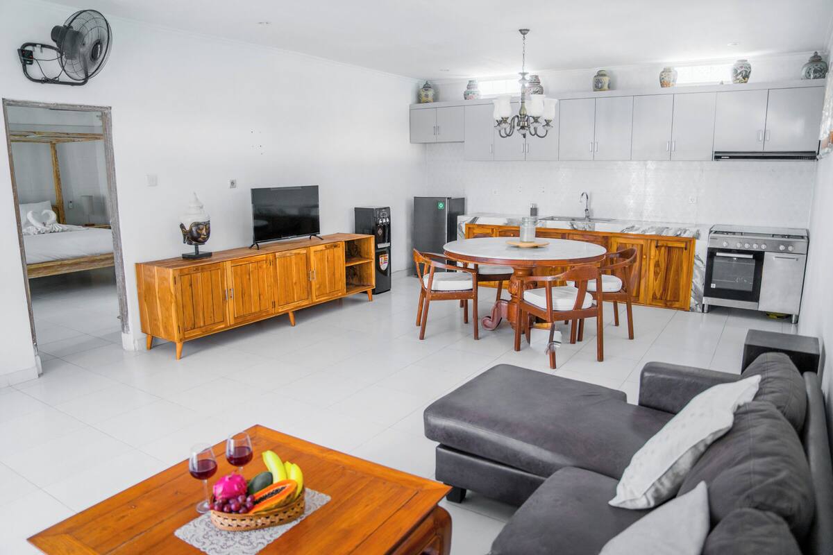 A compact living space with a kitchenette, dining area, and a sofa.