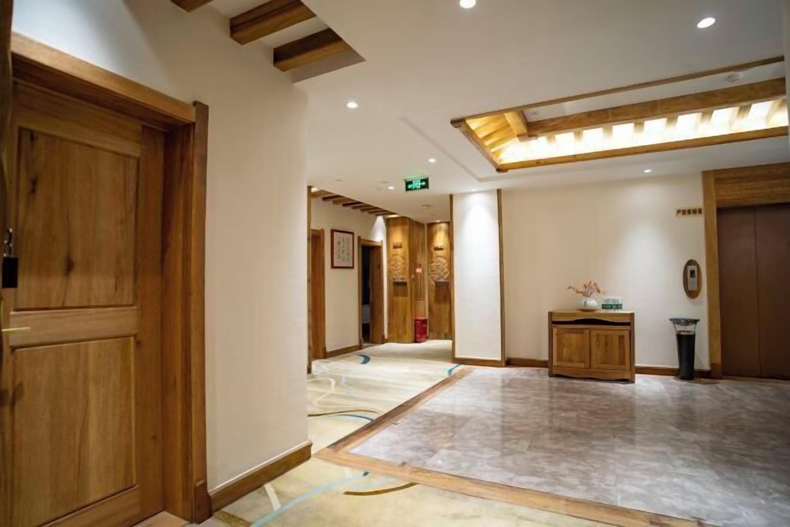 A hotel lobby with wooden paneling, a marble floor, and a reception desk.