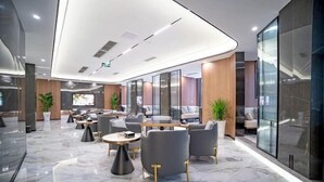 A modern hotel lobby with marble flooring, grey upholstered seating, and a central coffee table. - Shuhanyuan Hotel Mianyang (Mianyang)