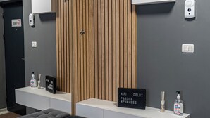 Ein modernes Badezimmer mit grauem und holzähnlichem Waschtisch, einem schwarzen Schild mit Text und einem Paar Hausschuhen auf dem Boden.