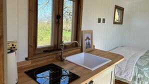 Una cocina compacta con encimera de madera, un lavabo y una estufa.
