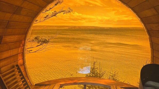 A wooden viewing platform with a circular opening, overlooking a landscape with a body of water and distant hills. - Off-grid TWO Glamping Bunkies on Bras d’Or - Marble Mountain/Lime Hill (Lime Hill)