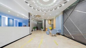 A modern reception area with a central desk, seating area, and a decorative ceiling. - Homeinn Motel Hotel (Nanjing Medical University Longmian Avenue Subway Station) (Nanjing)
