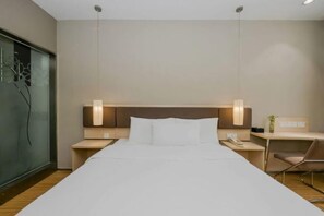 A hotel room with a large bed, two bedside tables, a desk, and a chair. - Homeinn Motel Hotel (Nanjing Medical University Longmian Avenue Subway Station) (Nanjing)
