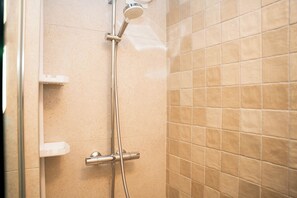 Regadera, secadora de cabello, toallas, papel de baño 