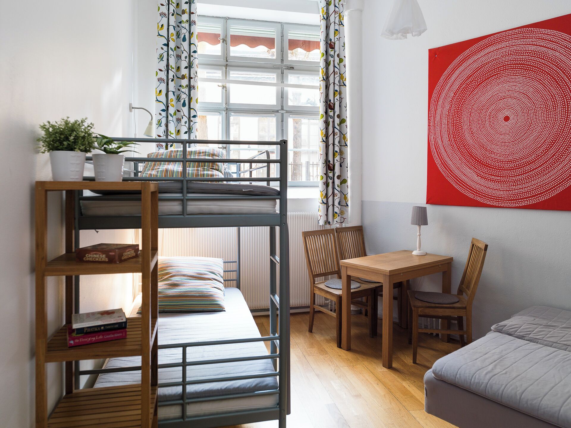 Ein Schlafsaalzimmer mit Etagenbetten, einem Schreibtisch, einem Stuhl und einem Bett.