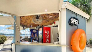 Een strandtentje met een Coca-Cola koelkast, een Hershey's ijsvriezer en een opblaasbare oranje reddingsboei.