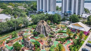 Een resort met een kenmerkende vulkanische rots, weelderige begroeiing en aangrenzende wolkenkrabbers.