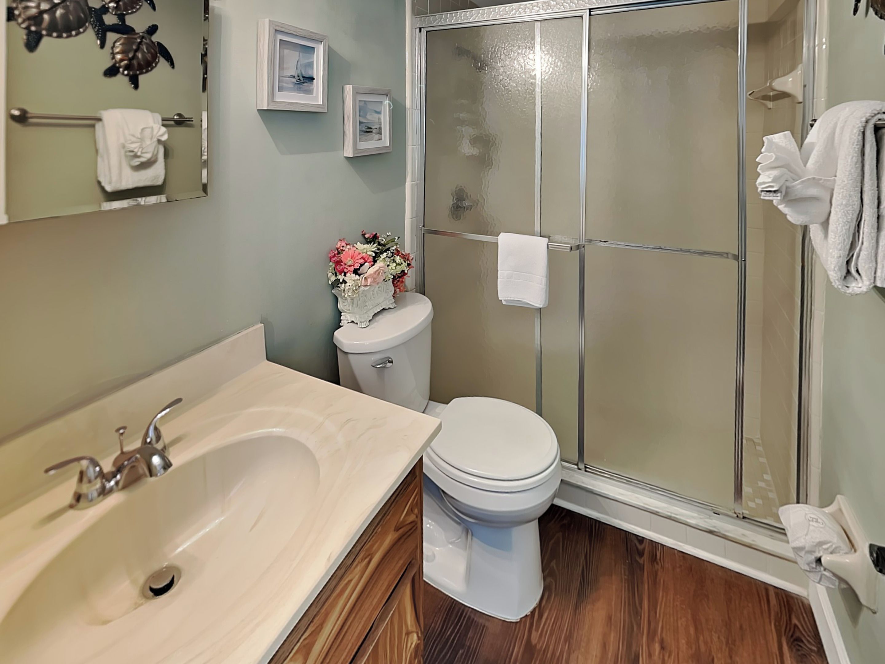 A bathroom with a bathtub, toilet, and glass shower enclosure.