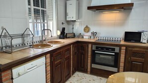 Een keuken met een vaatwasser, oven, magnetron en boiler.