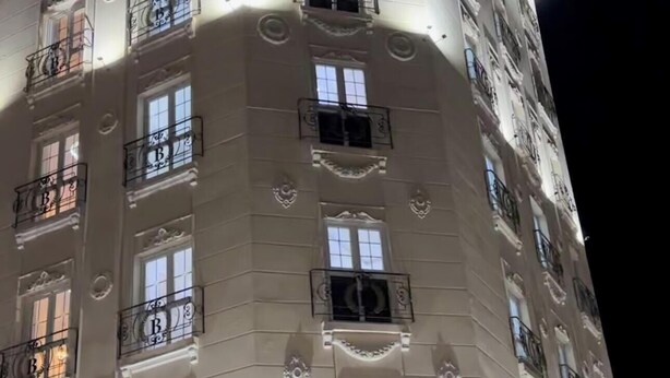 Ein mehrstöckiges Hotel mit beleuchteter Beschilderung, Balkonen und einer großen Eingangstür.