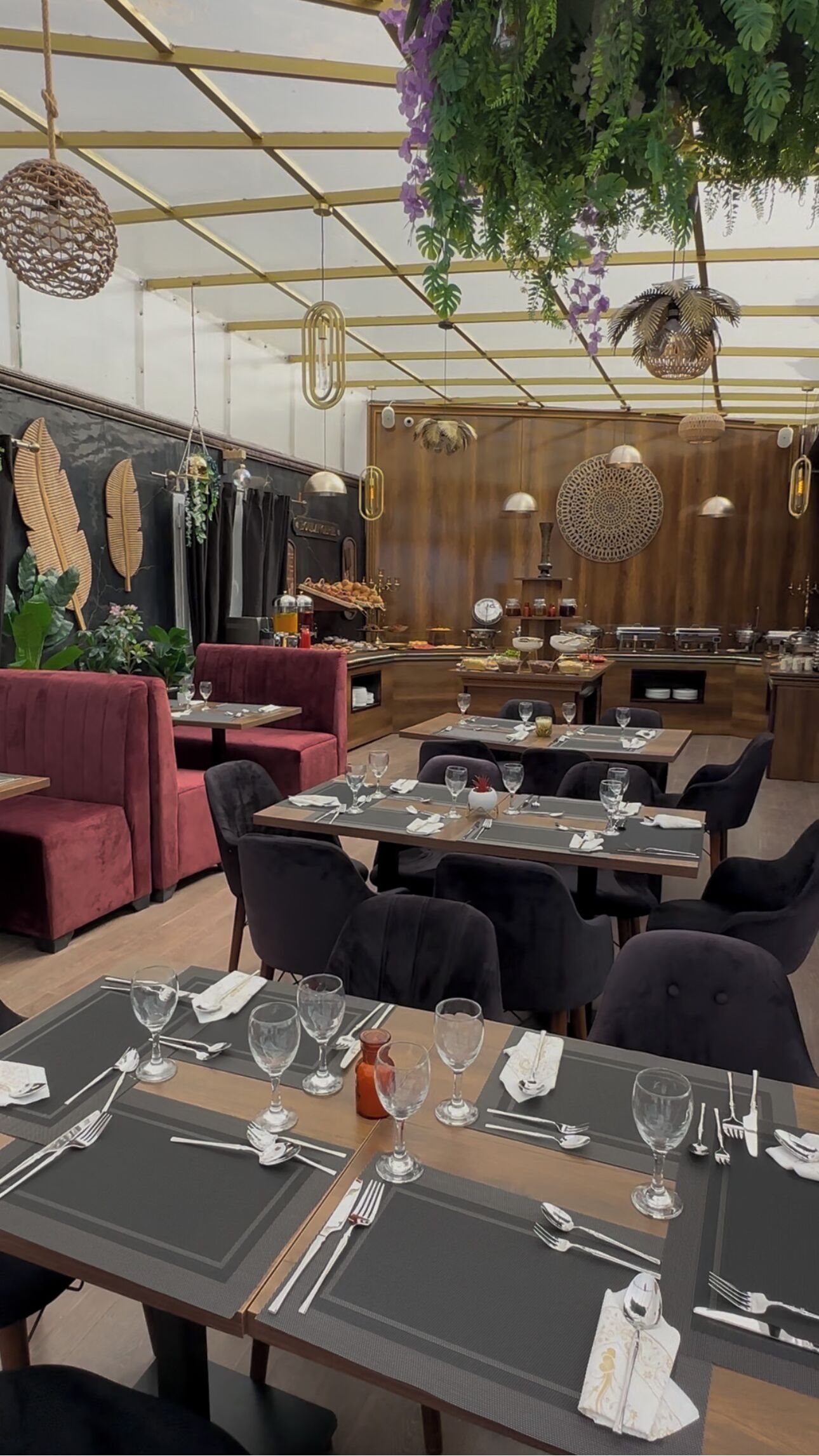A restaurant with tables set for dining, a bar area, and a seating section with cushioned booths.