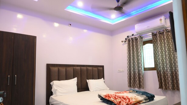 Un dormitorio con cama, armario, ventilador de techo, aire acondicionado y cortinas.
