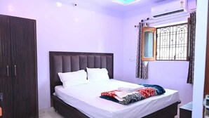 Un dormitorio con una cama grande, un armario y una ventana con rejas.