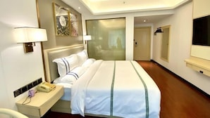 Une chambre d’hôtel avec un lit, une table de chevet, une lampe et un téléviseur.