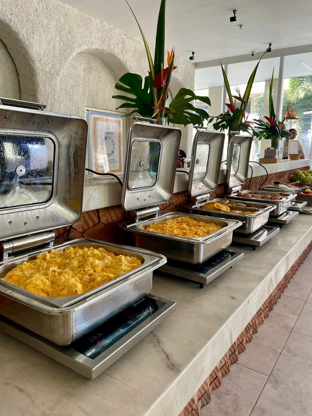 Dispositiu de buffet amb diversos plats i un dispensador d'aigua.